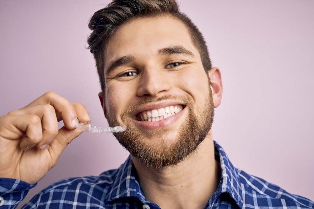 Mann zeigt Zahnschiene